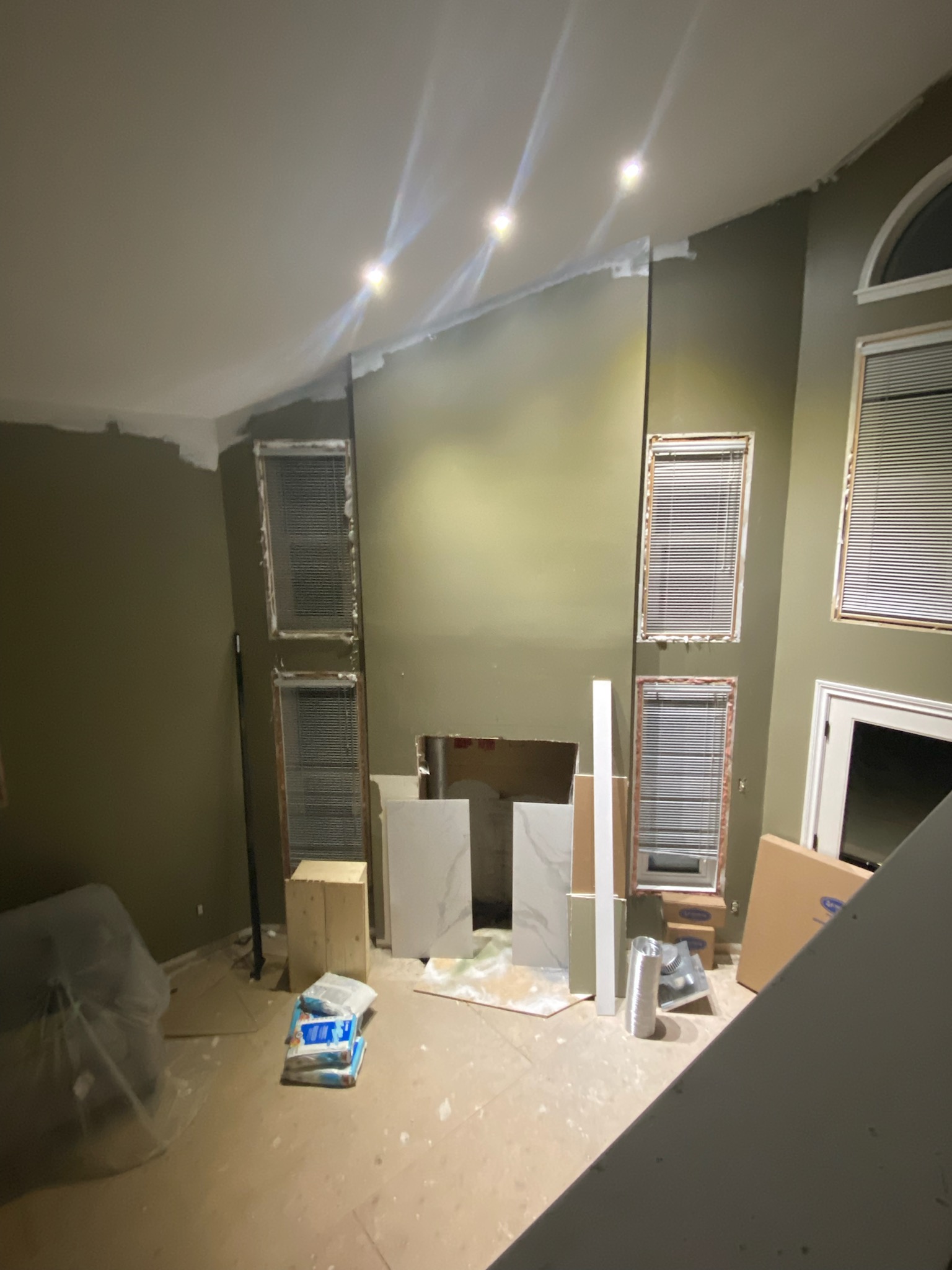 The before of a custom wall and lighting installation as part of a living room installation